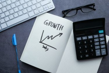 An illustration of business growth with notes, a calculator, and a keyboard in a workspace